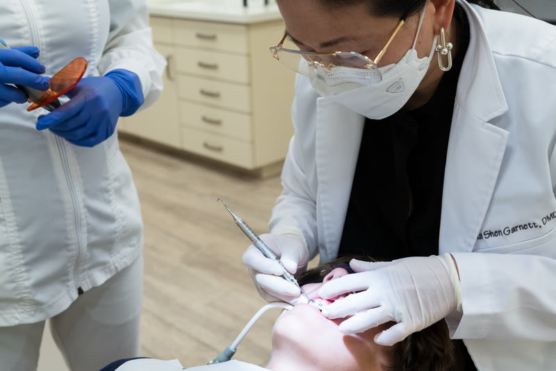 An orthodontist and assistant treating a patient in the practice